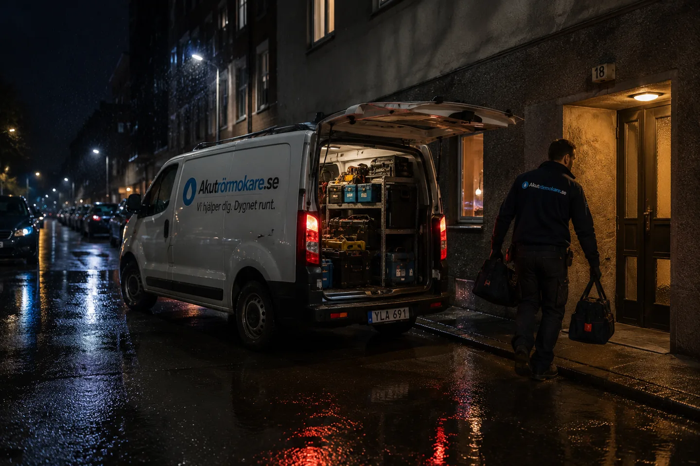 Servicebil med öppna bakdörrar på en nattgata medan rörmokaren går mot porten.